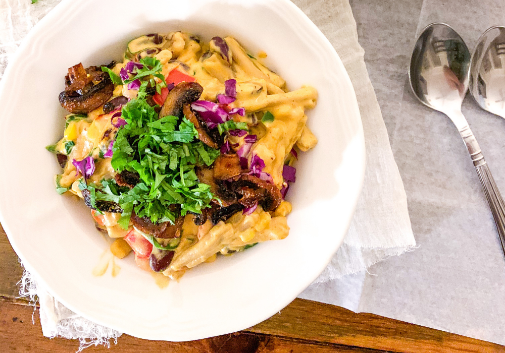 Healthy loaded mac & cheese with crispy smoky mushrooms in a bowl.