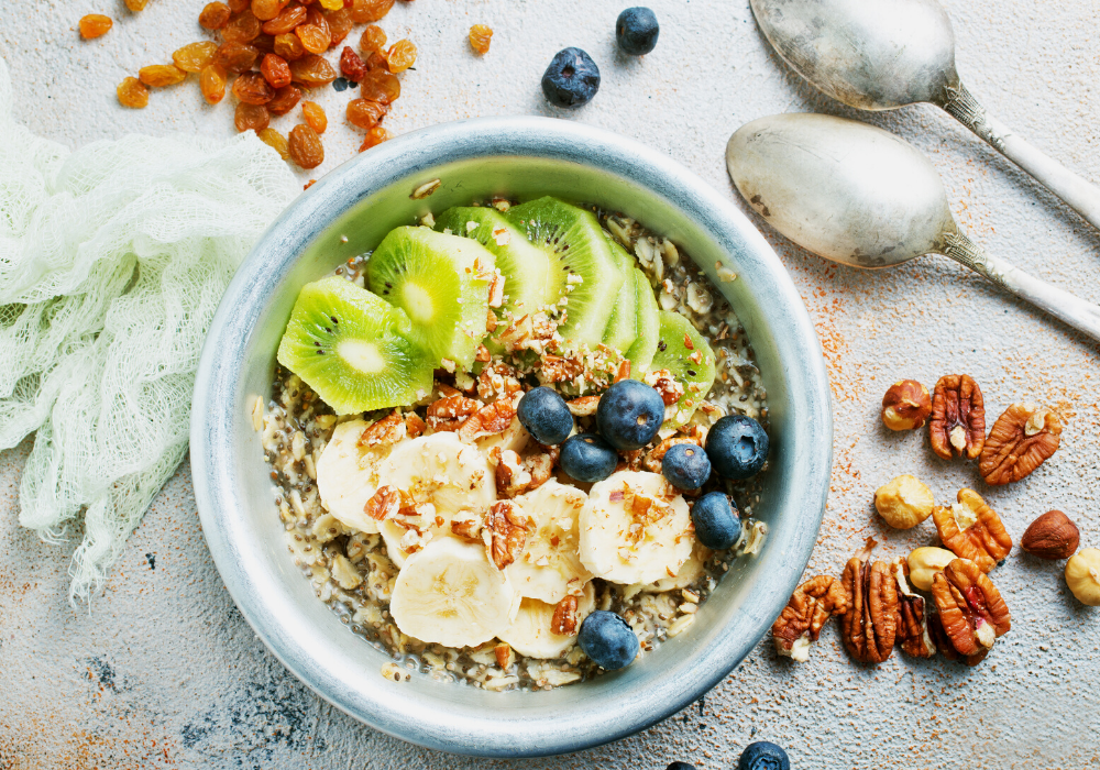 This image shows my typical breakfast: a bowl of oatmeal with berries, cut fruit, nuts, seeds, and soymilk.
